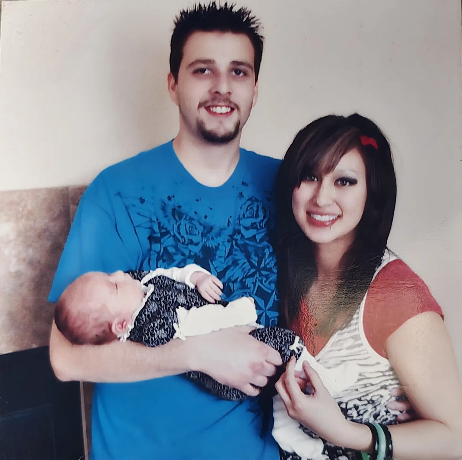Ken and Francesca smiling, Ken holding their newborn daughter.